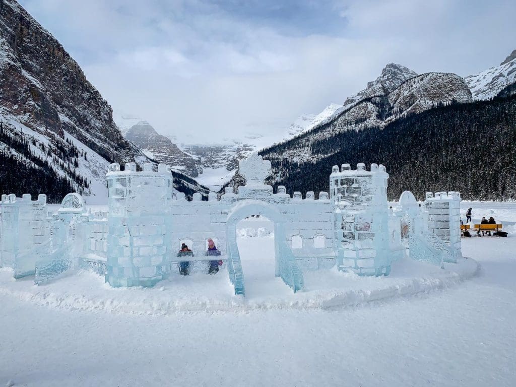 kids looking through the window of ice castle on Lake Louise.