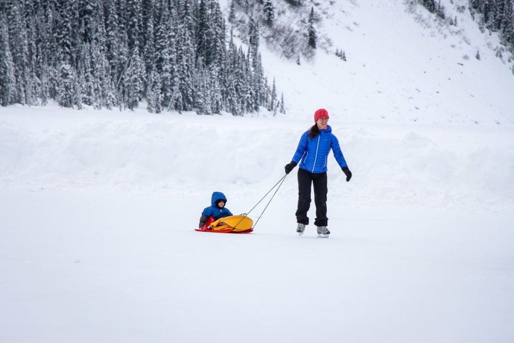 Celine Brewer and child skating on Lake Louise in Banff.