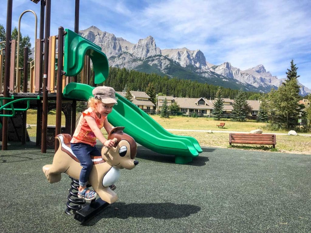 girl playing on playground in Canmore in summer.