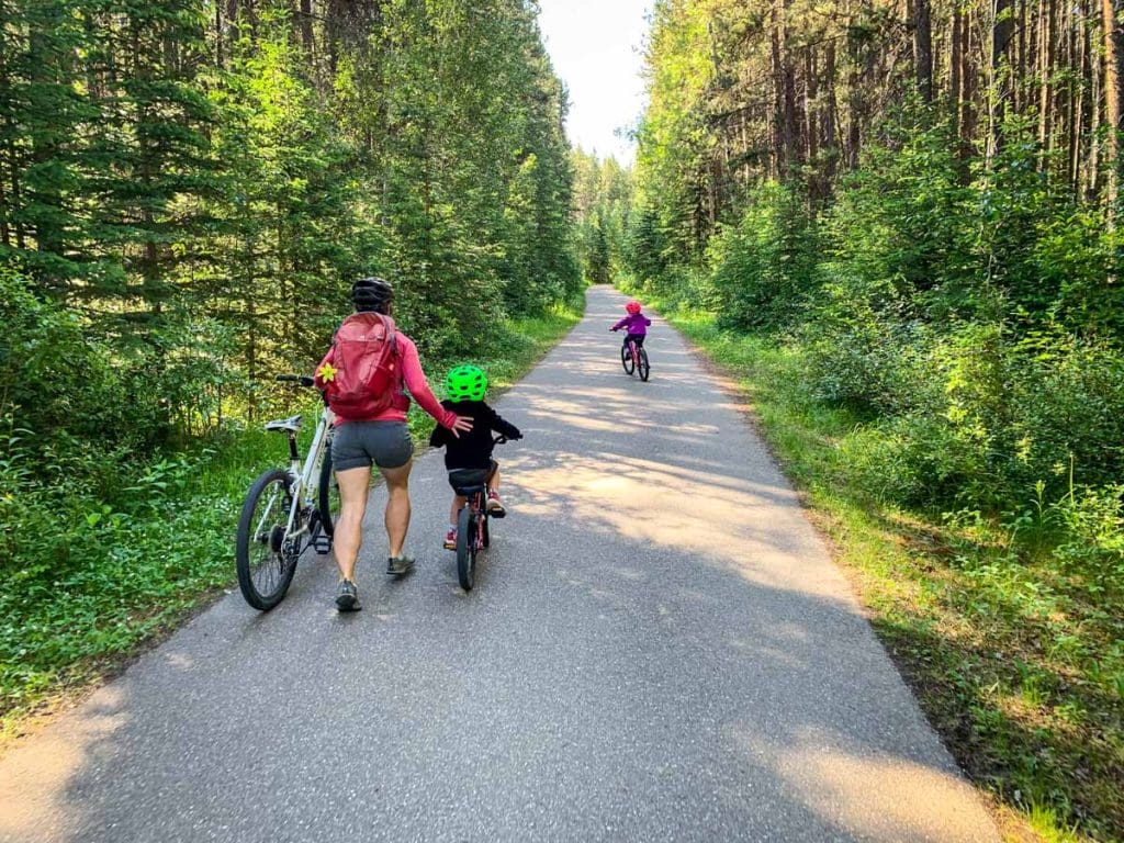 a mother pushing a bike helps a boy along the Sundance Canyon trail.