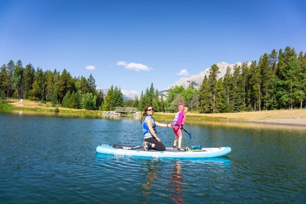 mother and daughter on a paddle board at Johnson Lake in Banff.