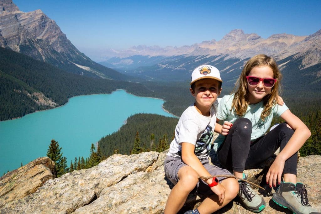 two kids posing for a picture in front of Peyto Lake along the Icefields Parkway in Banff National Park.