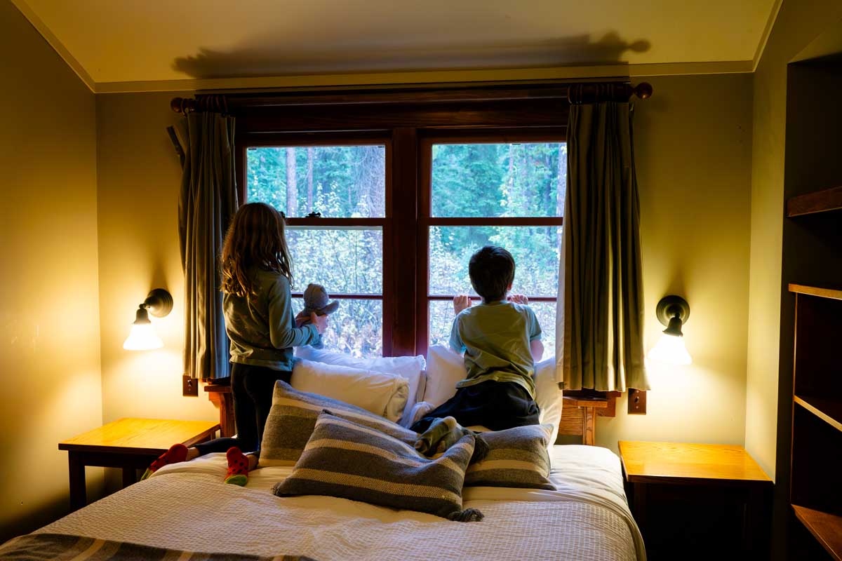 Kids looking out Window at Johnston Canyon Lodge & Bungalows
