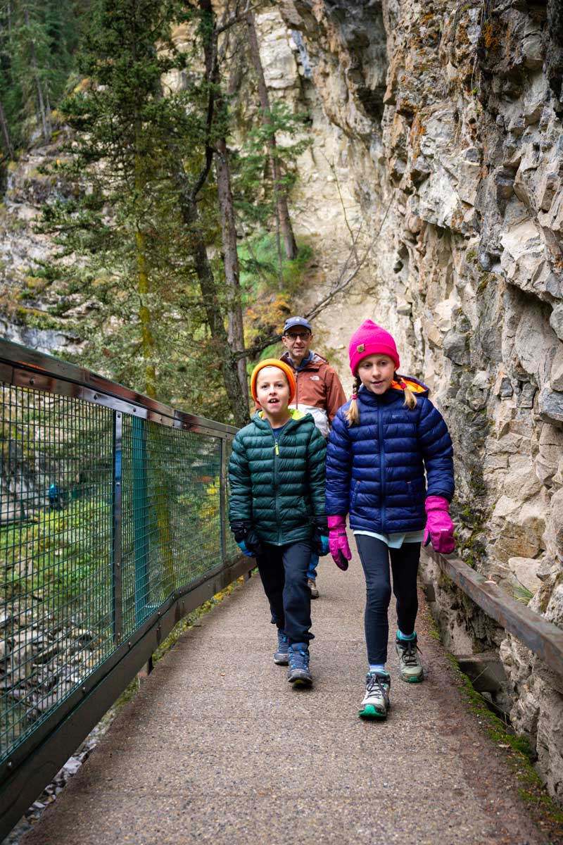 Two Kids and father walking along Johnston Canyon