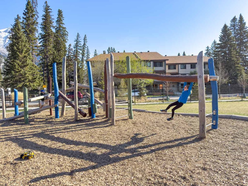 a 12-year old girl swings across the monkey bars at the Banff Elementary School playground in the Town of Banff.