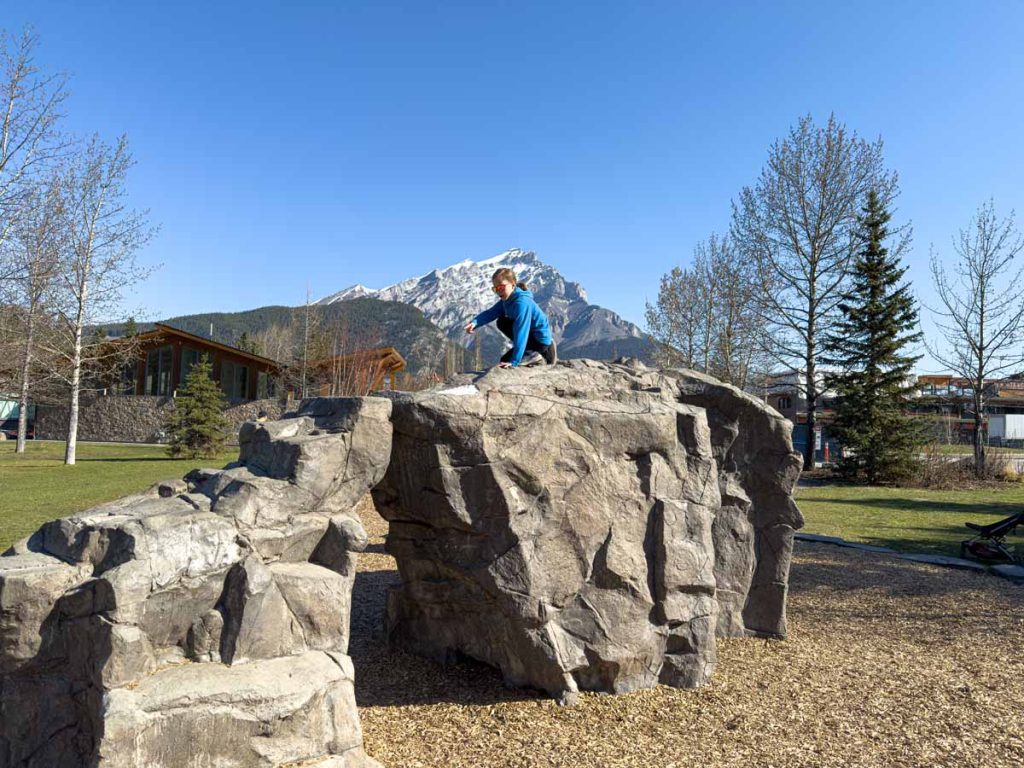 a 12-year old girl climbs on the rock structure in the Central Park Playground in the Town of Banff.