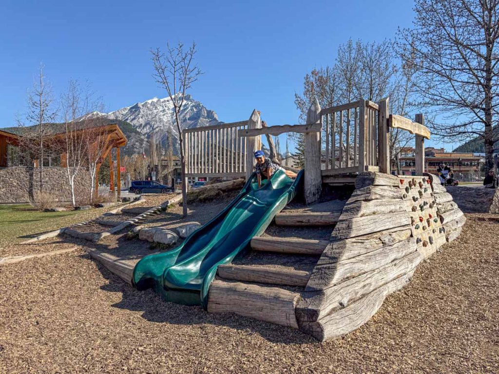 a 10-year old boy plays on the slides at the nature themed Central Park Playground in Banff, Canada.