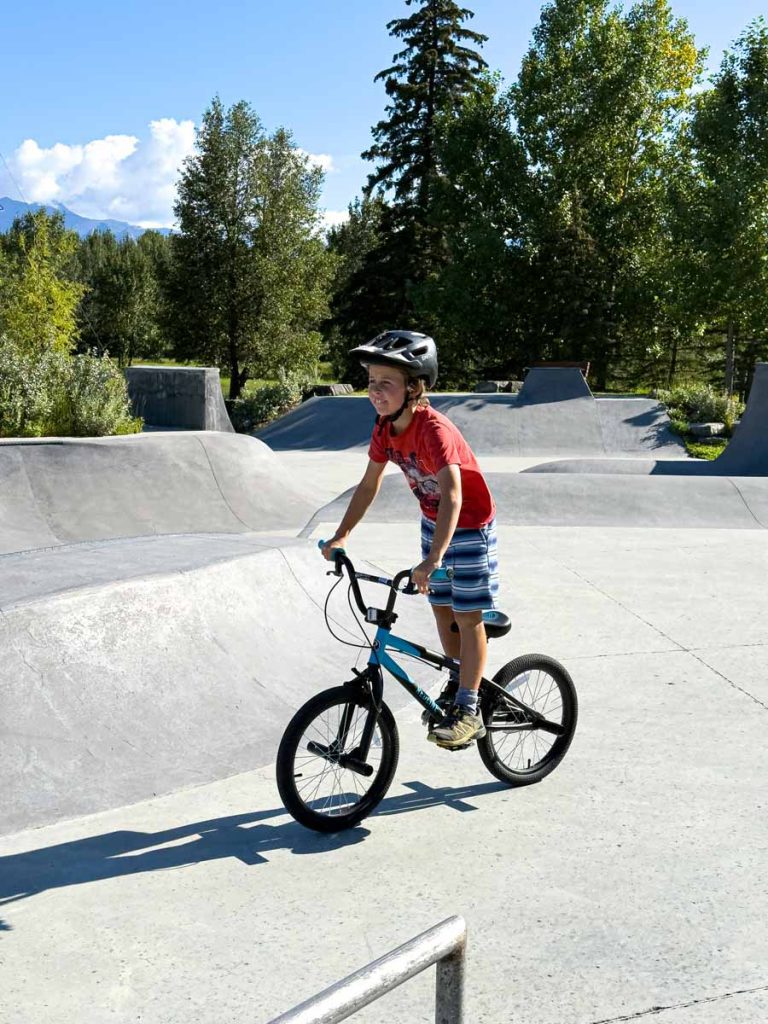 a 10-year old boy wears a biking helmet while on his BMX at the Banff Skatepark.