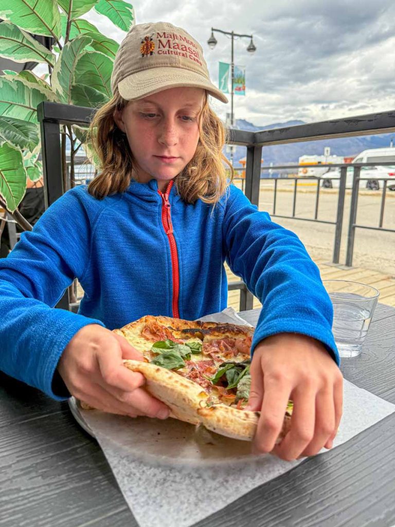 a 12-year old girl eats at the Jasper Pizza Company during a family trip to Jasper.