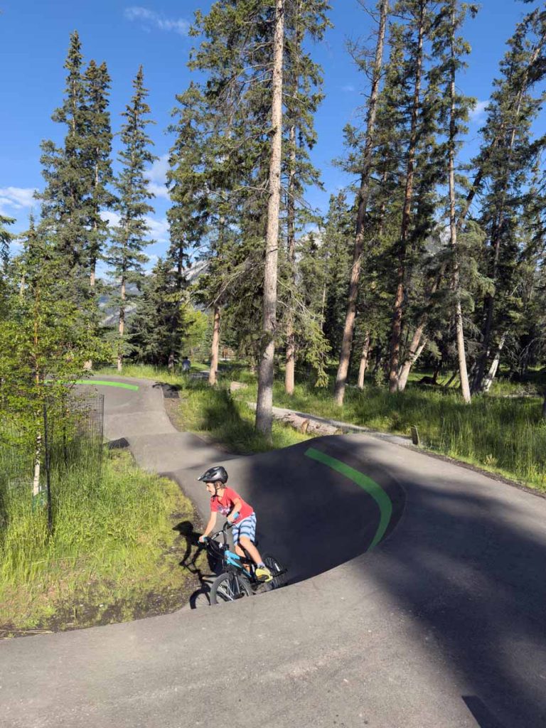 a 10-year old boy wears a mandatory helmet while riding his bike at the Banff Pump Track.
