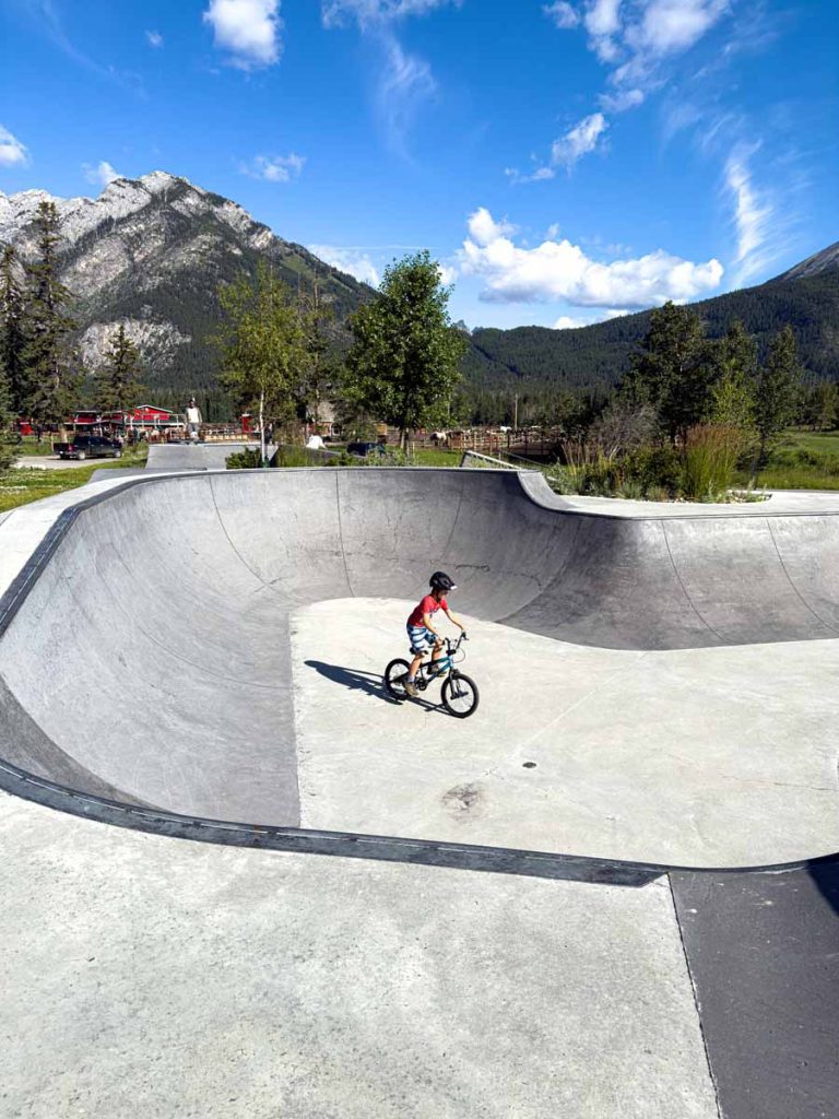 a 10-year old boy rides his BMX bike at the Banff skateboarding park.