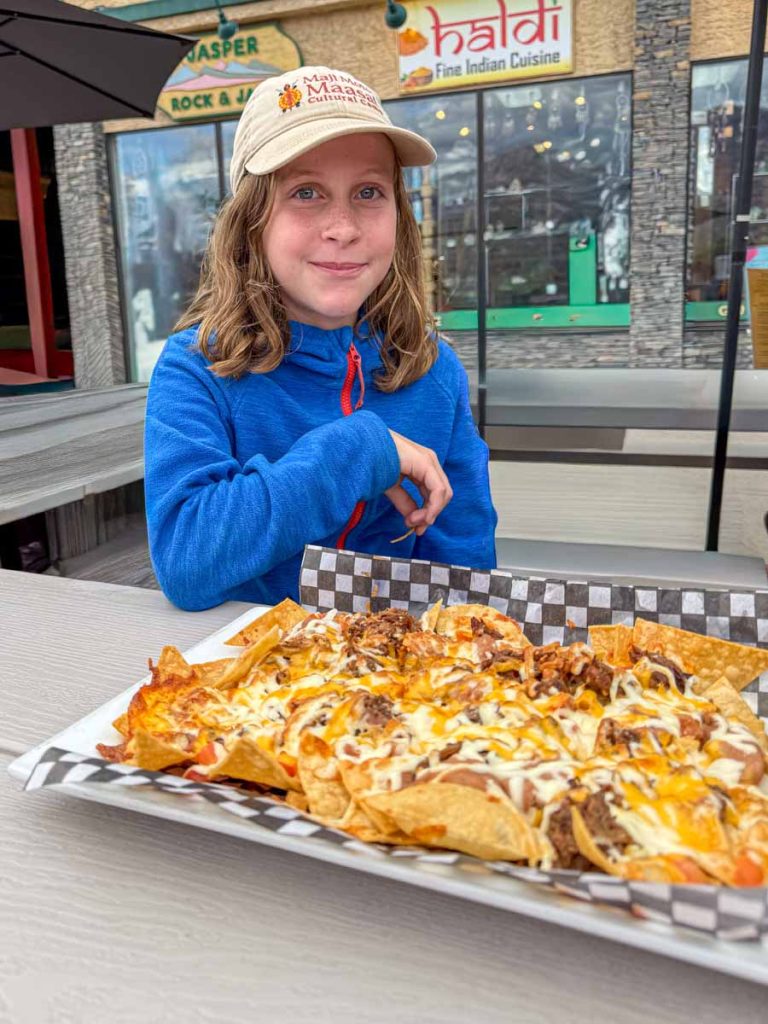 a 12-year old girl is excited to eat nachos at Su Casa Mexican Lounge in Jasper, Canada.