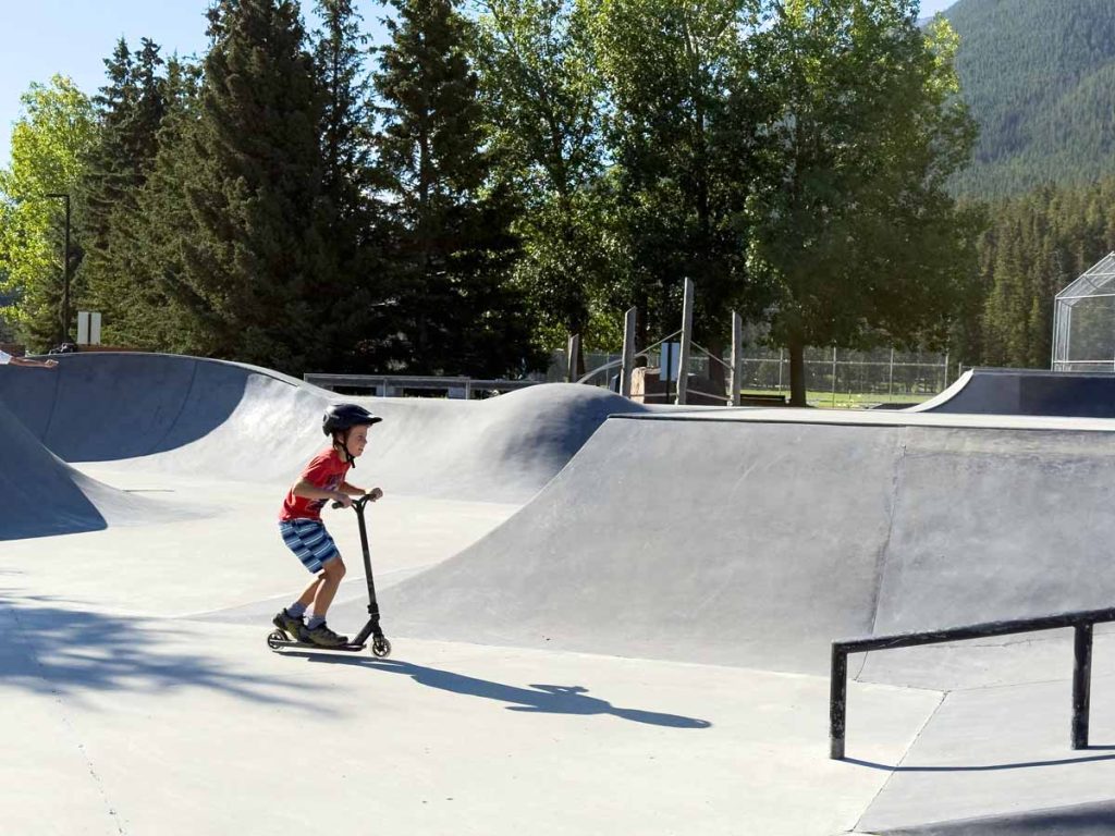 a 10-year old boy enjoys a nearly empty Banff Skatepark on a Saturday morning in August.